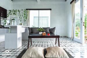 a living room with a couch and a table at D'Pendem Cottage's by Bukit Vista in Uluwatu