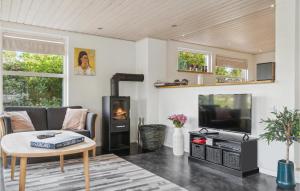 a living room with a fireplace and a tv at Beautiful Home In Væggerløse With Wifi in Marielyst
