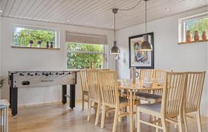 a dining room with a table and a piano at Beautiful Home In Væggerløse With Wifi in Marielyst