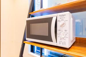a microwave sitting on top of a shelf at JA Hotel Namba in Osaka +24 photos