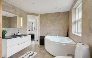 a bathroom with a tub and a sink and a toilet at Cozy Home In Humble With Sauna in Humble +16 photos
