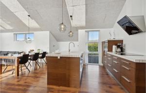 Una cocina y un comedor con mesa y sillas. en Three-Bedroom Holiday Home In Hemmet, en Falen