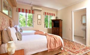 a bedroom with two beds and a bathroom at Rosedene Guest House in Cape Town