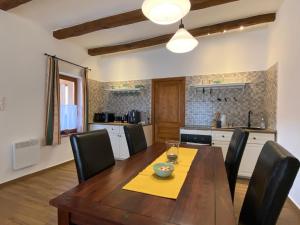 a kitchen with a wooden table and black chairs at Pilis lelke vendégház in Esztergom +8 photos