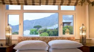 a bedroom with two pillows and a large window at Rosedene Guest House in Cape Town