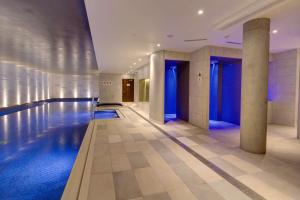 a swimming pool in a hotel with blue lighting at Hilton Bournemouth in Bournemouth +37 photos