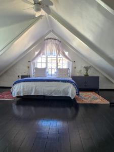 Un dormitorio con una cama en un ático con ventana. en Majestic Secret, en Ciudad del Cabo