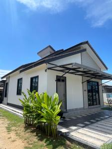 a white house with plants in front of it at Anjung Barakah Chalet in Kuala Terengganu +48 photos