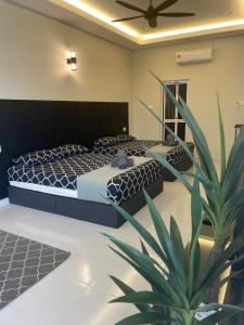 a bedroom with two beds and a potted plant at Anjung Barakah Chalet in Kuala Terengganu