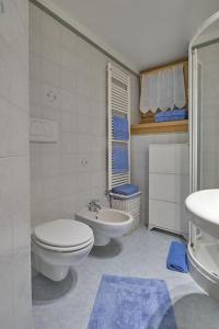 ein weißes Badezimmer mit Toilette und Waschbecken in der Unterkunft L'appartamentino del cuore in Bormio