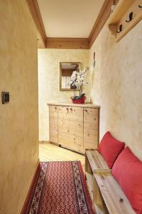 ein Wohnzimmer mit einer roten Couch und einer Kommode in der Unterkunft L'appartamentino del cuore in Bormio