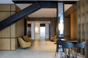 a lobby with chairs and a table and a staircase at Wyndham Garden Christchurch Kilmore Street in Christchurch
