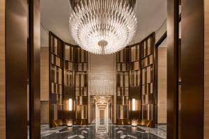 a hallway with a large chandelier and books at InterContinental Taichung by IHG in Taichung