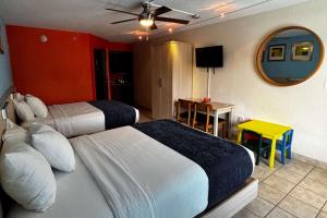 a hotel room with two beds and a mirror at Ramada by Wyndham Flamingo Water Park in Kissimmee +63 photos