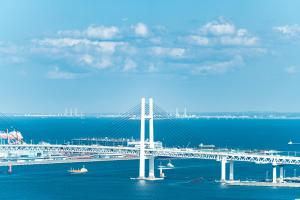 Four Points Flex by Sheraton Yokohama West في يوكوهاما: جسر أبيض فوق الماء عليه قوارب