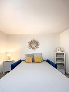 a bedroom with a large bed with two yellow pillows at Le Cocon Rochelais in La Rochelle