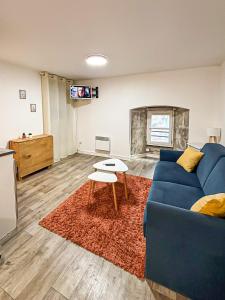a living room with a blue couch and a table at Le Cocon Rochelais in La Rochelle