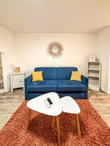 a living room with a blue couch and a table at Le Cocon Rochelais in La Rochelle +8 photos