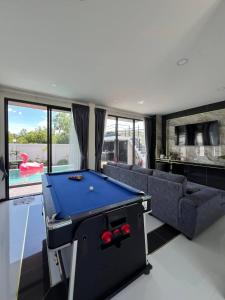 ein Wohnzimmer mit Billardtisch und Couch in der Unterkunft Carina PoolVilla Khanom คารีน่าพูลวิลล่า in Ban Phang Phrao