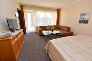 a hotel room with a bed and a couch at Haus "Luv und Lee" Appartement LEE06 in Döse