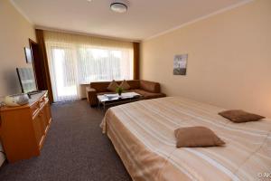 a hotel room with a large bed and a couch at Haus "Luv und Lee" Appartement LEE06 in Döse +10 photos