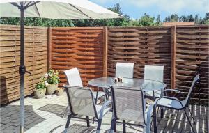 a patio with a table and chairs and an umbrella at Holiday Home Blomstervangen Ka Denm in Oksbøl