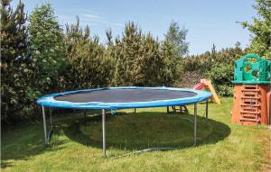 a trampoline in the grass next to a playground at Holiday Home Blomstervangen Ka Denm in Oksbøl