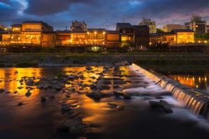 un fiume con rocce di fronte agli edifici di notte di Four Points Flex by Sheraton Osaka Umeda ad Osaka