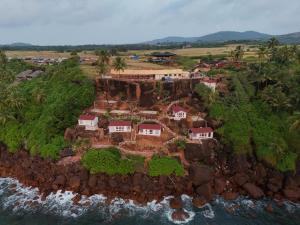an aerial view of a house on a rocky island at Red Crab Eco Resorts in Cabo de Rama