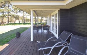 a porch with two chairs and a table on it at Holiday Home Stubbegårdsparken Nakskov Vi in Knubbeløkke