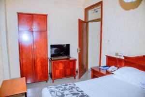 a bedroom with a bed and a tv on a cabinet at Kigali diplomat Hotel in Kigali