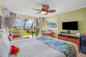 a bedroom with a bed and a flat screen tv at Islander on the Beach 154 in Kapaa