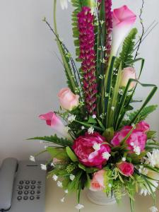 a bouquet of flowers in a vase on a table at The SR Residence Lampang in Lampang