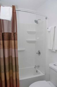 a bathroom with a shower and a tub and a toilet at Travelier Motel - Macon in Macon