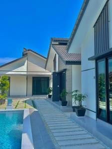 a house with a swimming pool next to a house at Anjung Barakah Chalet in Kuala Terengganu