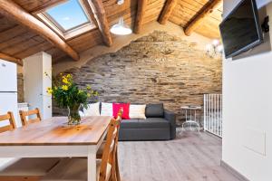 un salon avec une table et un canapé dans l'établissement Ático Casa Venancio, à Trabada