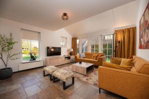 a living room with two couches and a tv at Buitengoed het Lageveld 64 in Hoge-Hexel