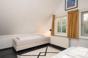 a bedroom with two beds and a window at Buitengoed het Lageveld 64 in Hoge-Hexel