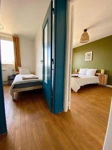 a bedroom with two beds and a blue wall at Centre ville Dijon Wilson *Chez Charles* 2Ch in Dijon +5 photos