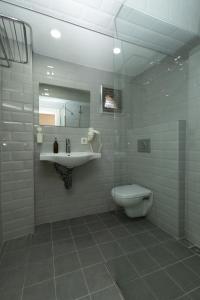 Un baño con lavabo, inodoro y espejo. en Deniz Pansiyon, en Izmir