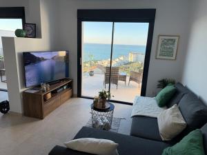 a living room with a couch and a flat screen tv at El Mirador Casa #8 in Torrox Costa
