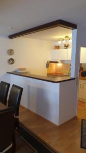 - une cuisine avec un comptoir et des chaises dans la chambre dans l'établissement Ferienhaus Norddeich 27, à Norden