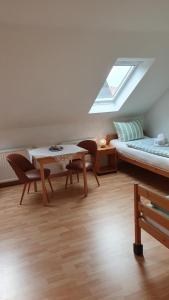 une chambre avec un lit, une table et des chaises dans l'établissement Ferienhaus Norddeich 27, à Norden