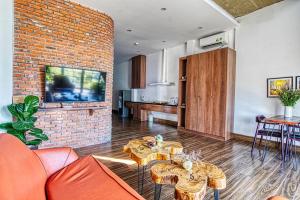 a living room with orange furniture and a brick wall at Chaca House in Danang