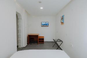 a white room with a bed and a desk at Deniz Pansiyon in İzmir