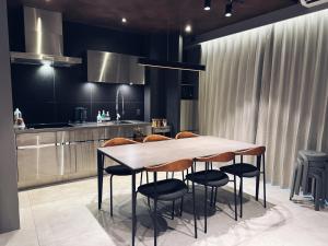 Una cocina con una mesa y sillas de madera. en TABISAI HOTEL Swell 天神, en Fukuoka