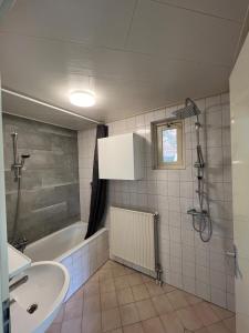 a bathroom with a sink and a bath tub at Huisje voor Rust, Ruimte en Natuur in Neede