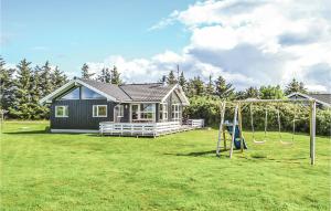 a small house with a playground in a yard at Holiday Home Laust Diges Vej Hvide Sande Vi in Havrvig