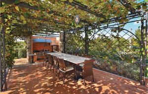 eine Terrasse mit Tisch und Stühlen unter einer Pergola in der Unterkunft Gorgeous Home In Sezana With Sauna in Sežana