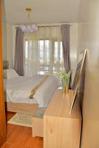 Un dormitorio con una cama y una mesa y una ventana. en Casamia luxury 2, en Nairobi 10 fotos más